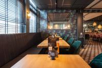 um restaurante com mesas de madeira e cadeiras verdes em Hotel-Appartementen Klaver Vier em Wagenborgen