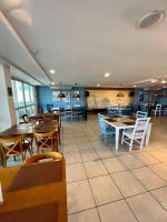 un ristorante con tavoli e sedie in legno e tavoli e sedie di Vista Mar - Resort Carioca - WIFI 500Mb a Rio de Janeiro