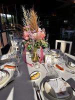 una mesa con platos blancos y un jarrón de flores en Villa Clorè Hotel & Spa, en Lama Mocogno