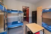 a dorm room with bunk beds and a table at Stayokay Hostel Amsterdam Vondelpark in Amsterdam