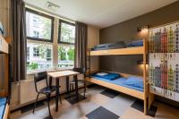 a room with bunk beds and a table and a desk at Stayokay Hostel Amsterdam Vondelpark in Amsterdam