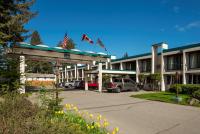 Un hotel con coches aparcados en un estacionamiento. en Prestige Riverside Lodge Quesnel, en Quesnel