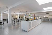 un restaurant avec un comptoir, des tables et des chaises dans l'établissement AluaSun Lago Park, à Cala'n Bosch