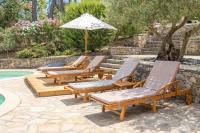 four lounge chairs and an umbrella next to a swimming pool at REVES DE PAMPA l APPART in Lorgues