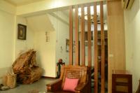 a living room with a chair and a large log at East of Love Homestay in Hualien City