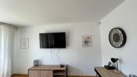 sala de estar con TV de pantalla plana en una pared blanca en Superbe appartement en centre-ville, 20min de Paris, 5 min d&#39;Enghien, en Saint-Gratien