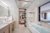 a bathroom with a tub and a sink and a bed at Four Seasons Hotel in Limassol