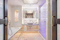a bathroom with a sink and a tub and a mirror at Four Seasons Hotel in Limassol