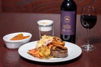 a plate of food with a bottle of wine and a glass at The Resort at Lake of the Ozarks in Lake Ozark