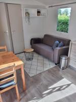 a living room with a couch and a table at Chalet Berg 616 op vakantiepark Bergumermeer aan het water in Suameer