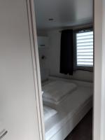 a small bed in a small room with a window at Chalet Berg 616 op vakantiepark Bergumermeer aan het water in Suameer