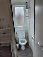 a small bathroom with a toilet and a window at Chalet Berg 616 op vakantiepark Bergumermeer aan het water in Suameer