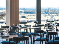 a restaurant with tables and chairs and a large window at Balgownie Estate Yarra Valley in Yarra Glen