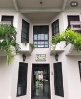 Un edificio blanco con palmeras delante. en Pousada da Jaqueira - EPP, en Rio das Ostras