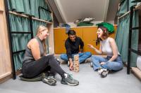eine Gruppe von Personen, die in einem Zimmer auf dem Boden sitzen in der Unterkunft The Bee Hostel in Amsterdam