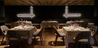 a dining room with tables and chairs and lights at Serras Andorra in Soldeu