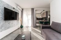 a living room with a couch and a tv on a wall at Luxury D Apartments in Bibinje