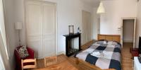 a bedroom with a bed and a fireplace and a chair at VIEUX LILLE Porte de Gand Bienvenue chez NESTYOU, Lille in Lille
