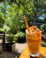 een drankje zittend op een houten tafel bij Les Chalets de Labeaume in Labeaume