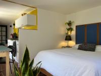 a bedroom with a bed and a table and a kitchen at Gîte cosy sur jardin in Moëlan-sur-Mer