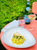 un plato de pasta en una mesa con una botella de vino en Hotel van Bebber, en Xanten