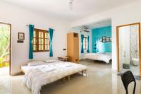 Un dormitorio con dos camas y un espejo. en Casa De Mor Room with Pool, en Anjuna