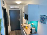 eine kleine Küche mit einer Theke und einer blauen Tür in der Unterkunft Málna Apartman Juventus in Balatonföldvár