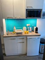 eine Küchentheke mit einer Spüle und einer Mikrowelle in der Unterkunft Málna Apartman Juventus in Balatonföldvár