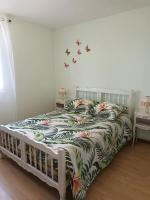 a bedroom with a bed with a bedspread with butterflies on it at Maison pavillonnaire in Lanvollon