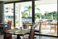 un restaurante con mesas y sillas y vistas a la piscina en Aquashow Park Hotel, en Quarteira