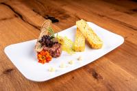 un plato blanco con comida en una mesa de madera en Hotel B&B Feldmessner, en Brunico