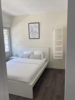 a white bedroom with a bed with white sheets and pillows at Le Cosy Agen-Proche Gare-Salle de sport-Vidéoprojection in Agen