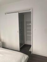 a bedroom with a glass door leading to a closet at Le Cosy Agen-Proche Gare-Salle de sport-Vidéoprojection in Agen