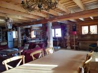 a dining room and living room with a table and chairs at Magnifique chalet en rondins avec sauna - Vercors in Villard-de-Lans