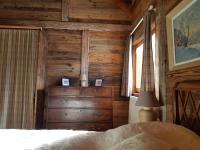 a bedroom with wooden walls and a dresser and a bed at Magnifique chalet en rondins avec sauna - Vercors in Villard-de-Lans