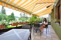 una mujer sentada en una mesa en un patio en Zajazd Karłów Restauracja & Pokoje Gościnne, en Karłów