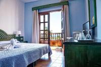 Łóżko lub łóżka w pokoju w obiekcie Hotel Jardín Concha