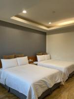 two beds in a room with white sheets at Lutai B&amp;B in Yung-an-ts&#39;un