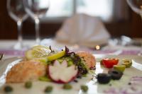un plato de comida con un limón en una mesa en Hotel Rössli Tufertschwil, en Lütisburg