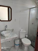 a bathroom with a toilet and a sink and a shower at Pousada Exuberante in Abraão