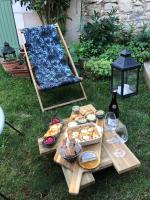 a picnic table with food and wine on the grass at Les 3 échoppes in Chargé