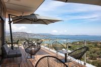 a balcony with chairs and a table and an umbrella at Hotel Alcyon in Porto-Vecchio