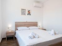 a bedroom with a bed with white sheets and towels at Apartment Santa Marina 4 in Asgourou