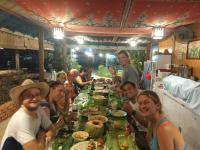 a group of people sitting around a table eating food at Langkawi Country Lodge2 in Pantai Cenang