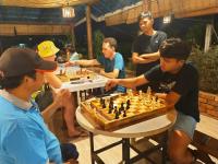 a group of men playing a game of chess at Langkawi Country Lodge2 in Pantai Cenang