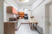 a kitchen with white cabinets and a table with flowers on it at La Maison des Fées in Pleudihen-sur-Rance