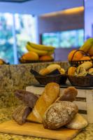 Un montón de diferentes tipos de pan en una tabla de cortar en Hotel Capital Bellet, en Santiago