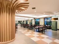 een restaurant met tafels en stoelen en een geruite vloer bij Uni-Resort Mawutu in Guanxi