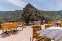 un patio con mesas, sillas y una montaña en Hotel Restaurante Felipe II, en Ayna