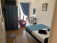 a bedroom with a bed and a chair and a window at Le Cérétan Hôtel in Céret